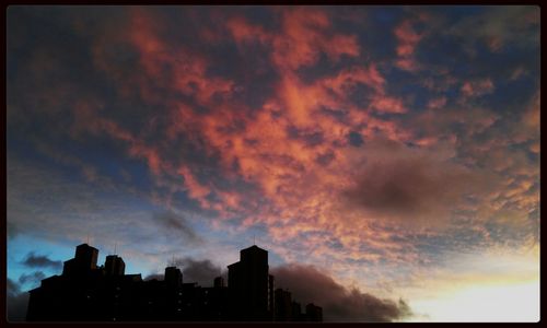 Silhouette of building against cloudy sky