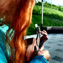 Midsection of woman playing ukelele at park