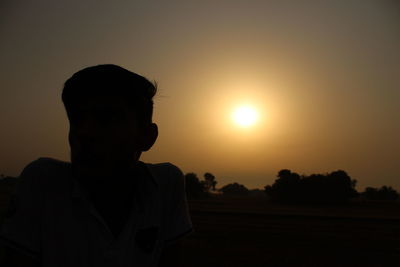 Silhouette boy against sky during sunset