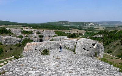 High angle view of woman standing on rock formation over landscape