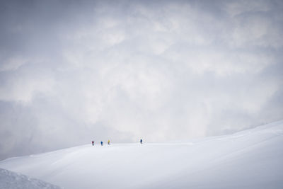 Mountaineers going down the snowy ridgeline with clouds in backdrop, mount ararat in turkey