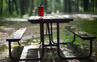 Empty bench in park during rainy season