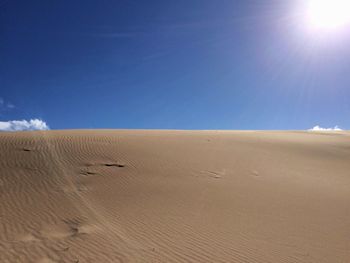 Scenic view of desert against blue sky