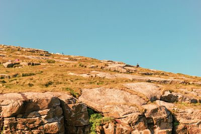 Rock formations on landscape against clear blue sky