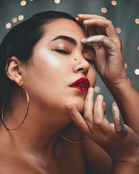 Woman with red lipstick hands on her face eyes closed