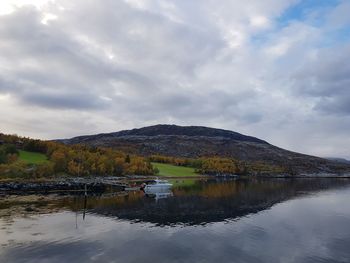 Scenic view of lake by mountain against sky