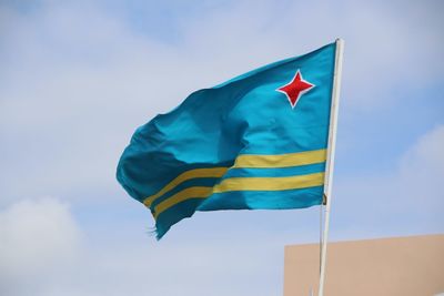 Low angle view of flag flags against sky