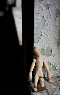 Close-up of wooden figurine on window sill