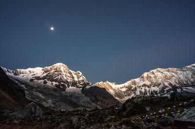 Scenic view of snowcapped mountains against sky at night