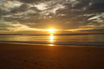 Scenic view of sea against dramatic sky during sunset