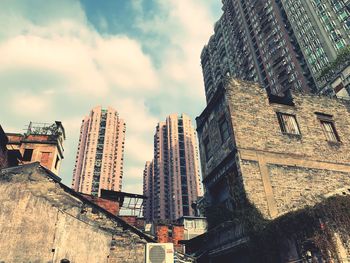 Low angle view of buildings against cloudy sky