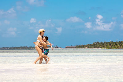 Mother and son hugging on a tropical beach