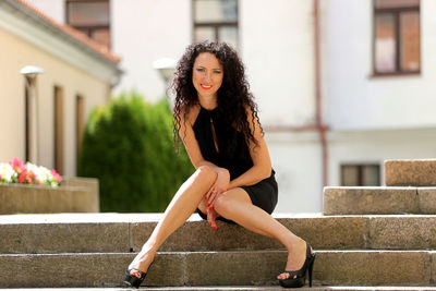 Portrait of smiling mature woman sitting on steps