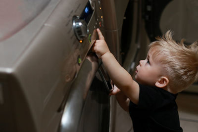 Side view of boy looking through window