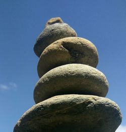 Low angle view of stack against blue sky