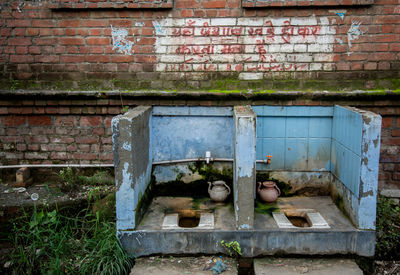 View of dirty unhygienic toilets next to brick wall