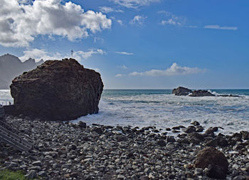 Rock formations in sea against sky