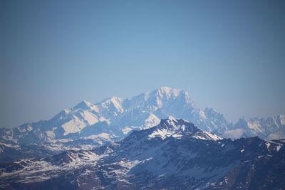 Scenic view of snowcapped mountains against clear blue sky