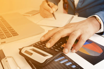 Midsection of man using laptop on table