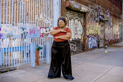 Portrait of woman standing against graffiti