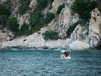 People on river amidst rocks