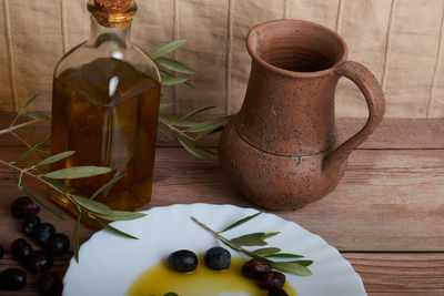 Striking oil bottles surrounded by several ripe olives