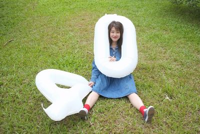 Low section of woman sitting on grassy field