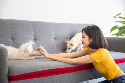 Woman with dog sitting on sofa