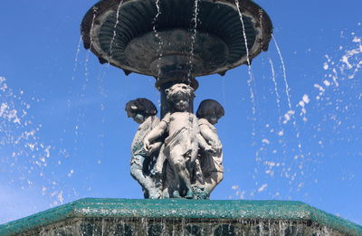 Low angle view of statues against clear blue sky