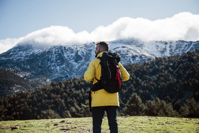 Young man with yellow jacket and backpack in the mountains.