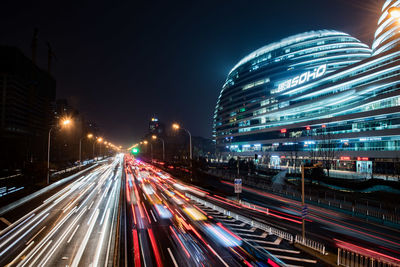 Light trails on road against sky at night