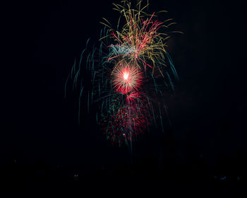 Low angle view of firework display at night