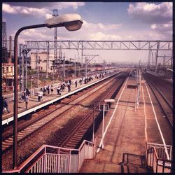 Railroad tracks against cloudy sky