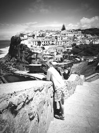People in sea against buildings in city