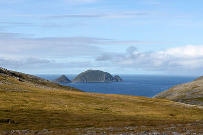 Scenic view of sea and mountains against sky