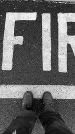 Low section of man standing on road