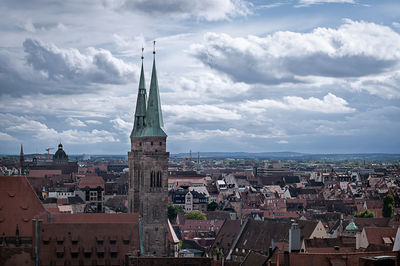 Aerial view of townscape against cloudy sky