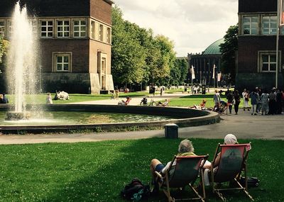 People in park against buildings in city