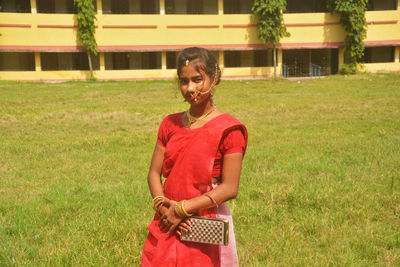Full length of smiling woman standing on field