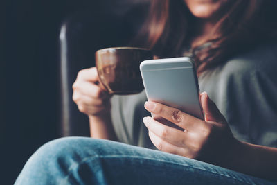 Midsection of man using mobile phone