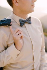 Midsection of man wearing bow