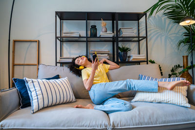 Woman sitting on bed at home