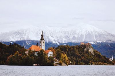 Scenic view of the autumn snow-capped mountains against the slovenian lake bled.