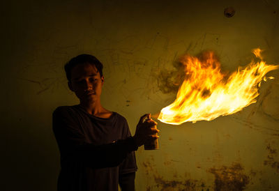 Man standing against fire at night