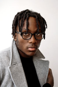 Stylish black man wearing glasses and coat portrait