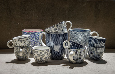 Close-up of mugs and cups on table