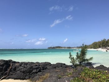 Scenic view of turquoise sea, beach and bay , volcanic rock 