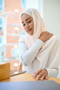 Businesswoman wearing hijab having back ache