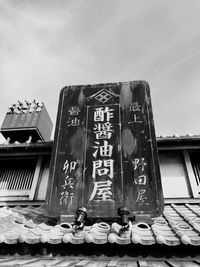 Low angle view of information sign against sky