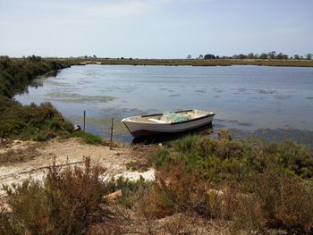 Boat moored in river against sky